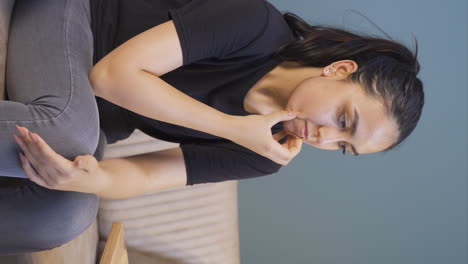 Vertical-video-of-Troubled-young-woman-looking-at-knife-and-pills-in-front-of-her.